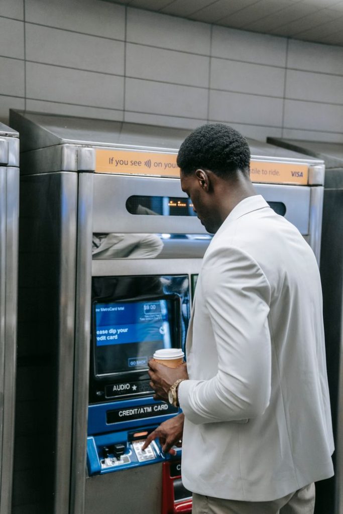 Mastering the First Impression: Your intriguing post title goes here Businessman with coffee uses ATM indoors. Finance and transactions made simple.